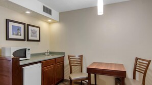 A compact kitchen with a microwave, sink, and two chairs around a small table. - Comfort Inn Chester - Richmond South (Chester)