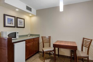 A compact kitchen with a microwave, sink, and two chairs around a small table. - Comfort Inn Chester - Richmond South (Chester)