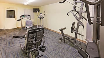 Uma academia com esteiras, elípticos e equipamentos de musculação.