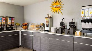 Un buffet pour le petit-déjeuner proposant divers aliments et une machine à café.