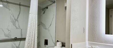 A bathroom with a shower, toilet, and sink.