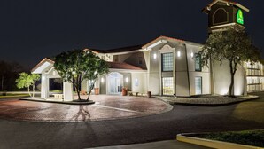 Un hôtel bien éclairé, doté d’un beffroi imposant, d’une entrée couverte et d’une allée pavée.