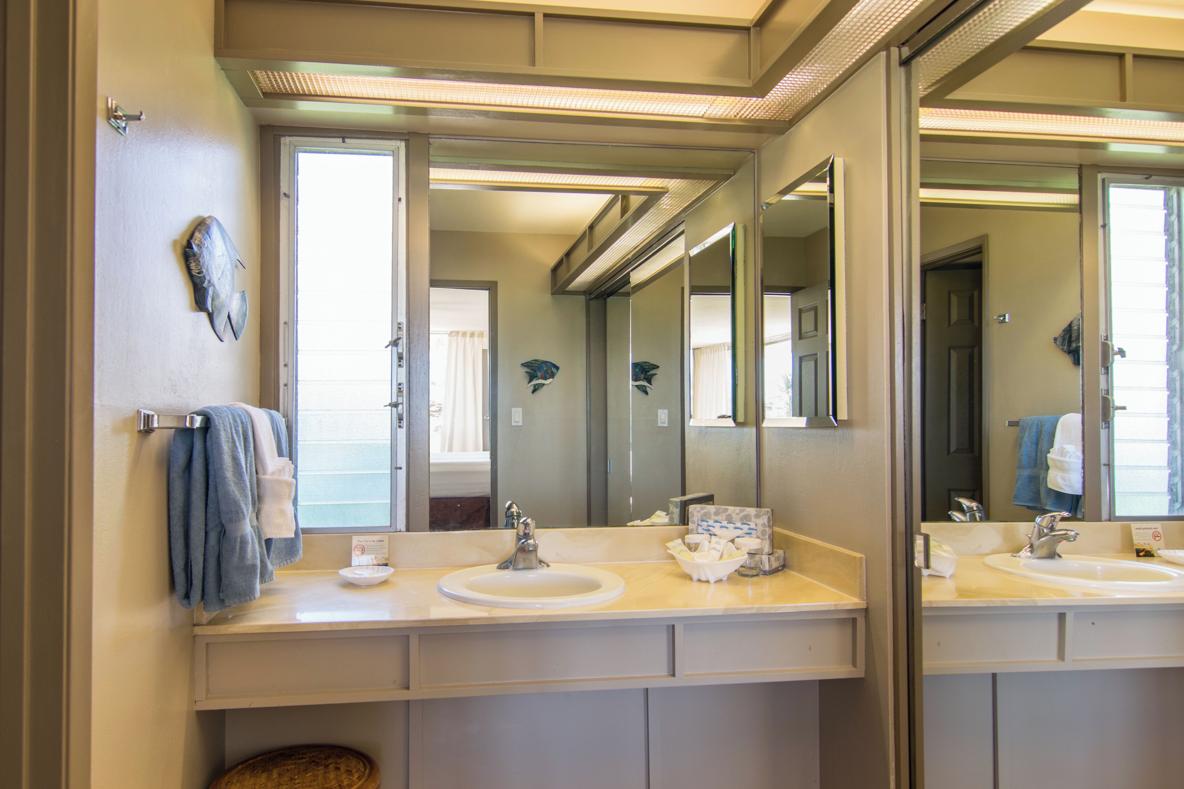 Une salle de bain avec deux lavabos, un grand miroir et un porte-serviettes.