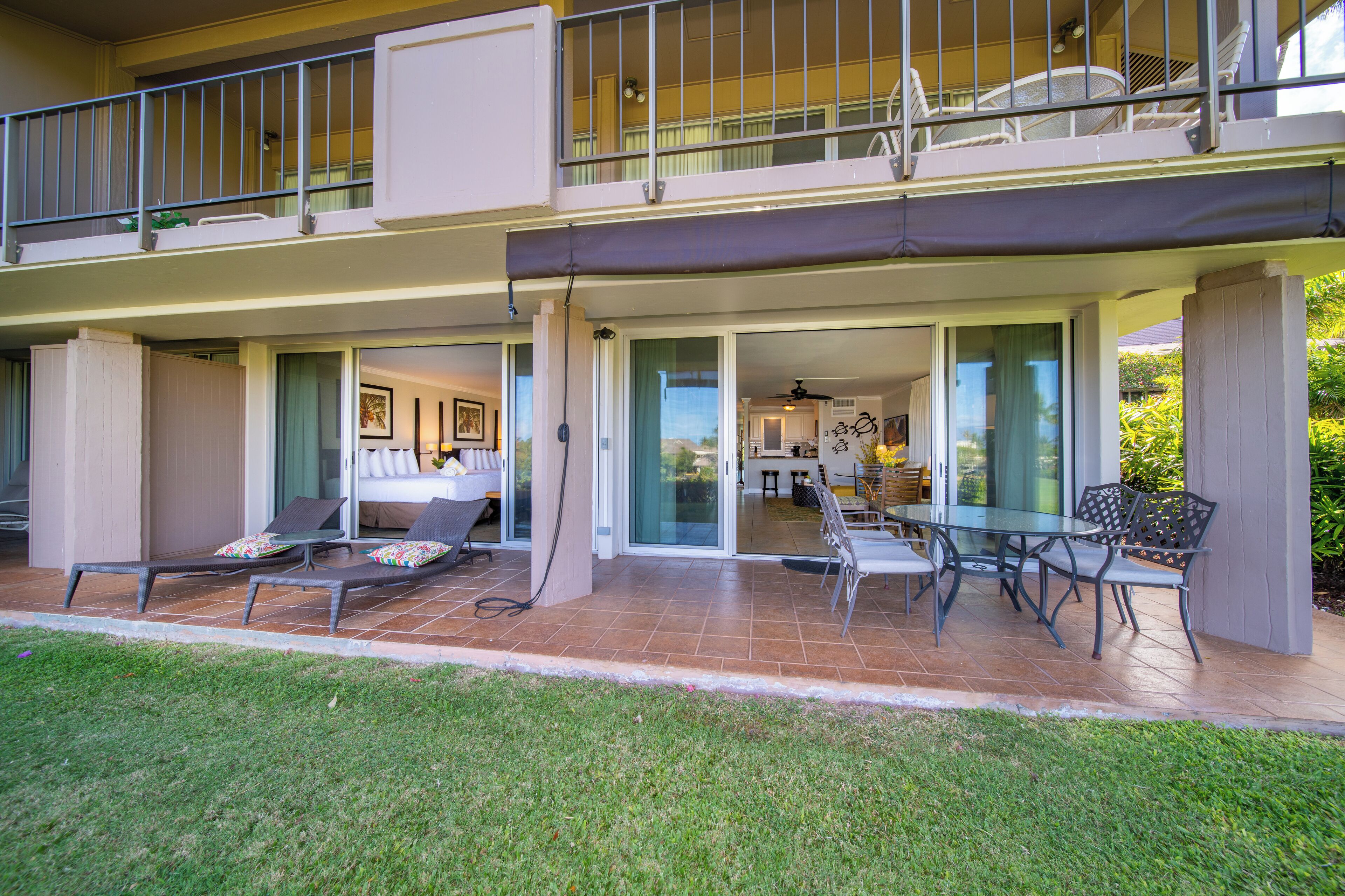 A two-story building with a balcony, a dining area with a table and chairs, and a view of the interior.