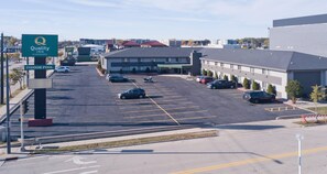 A parking lot with multiple cars, a Quality Inn sign, and a building with a red roof.