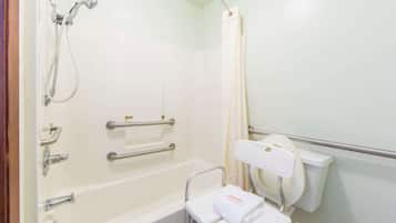A bathroom with a bathtub, shower, grab bars, a toilet with a safety seat, and a towel rack.