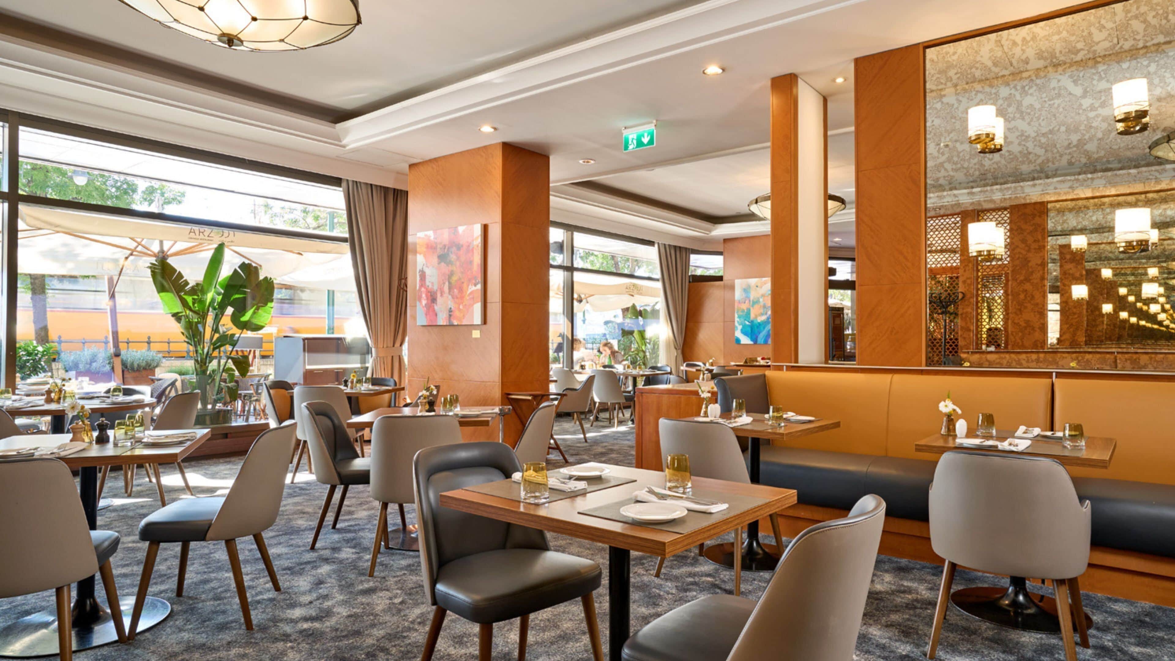 A restaurant with indoor seating, tables, chairs, and a bar area.