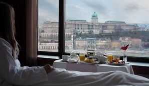 Habitación de hotel con vistas a un edificio histórico grande a través de una ventana.