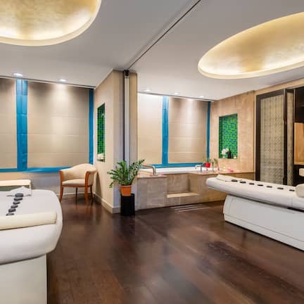 A spa room with a massage table, a seating area, and a reception desk.