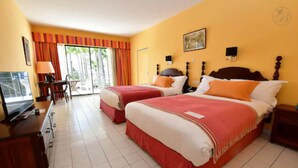 A hotel room with two beds, a desk, a TV, and a view of the outdoors. - Hotel Bakoua Les Trois Ilets (Trois-Ilets)