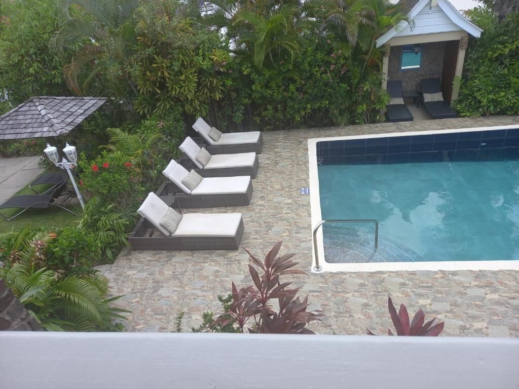 A rooftop pool area with lounge chairs and a hot tub.