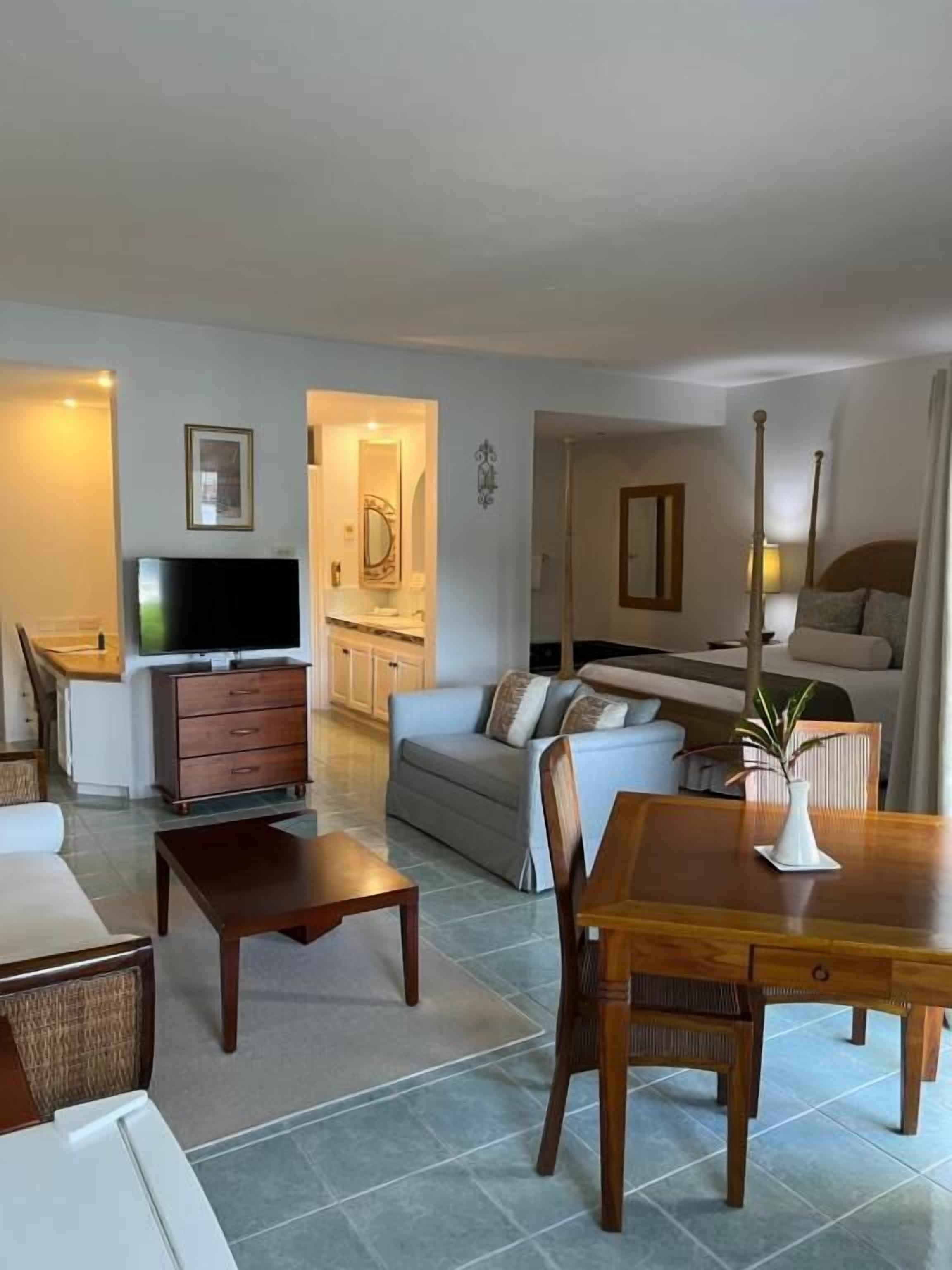 Un salon comprenant un canapé, une table basse, un téléviseur et une table à manger avec des chaises.