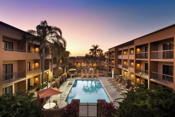 Relax by the pool surrounded by lounge chairs and umbrellas.
