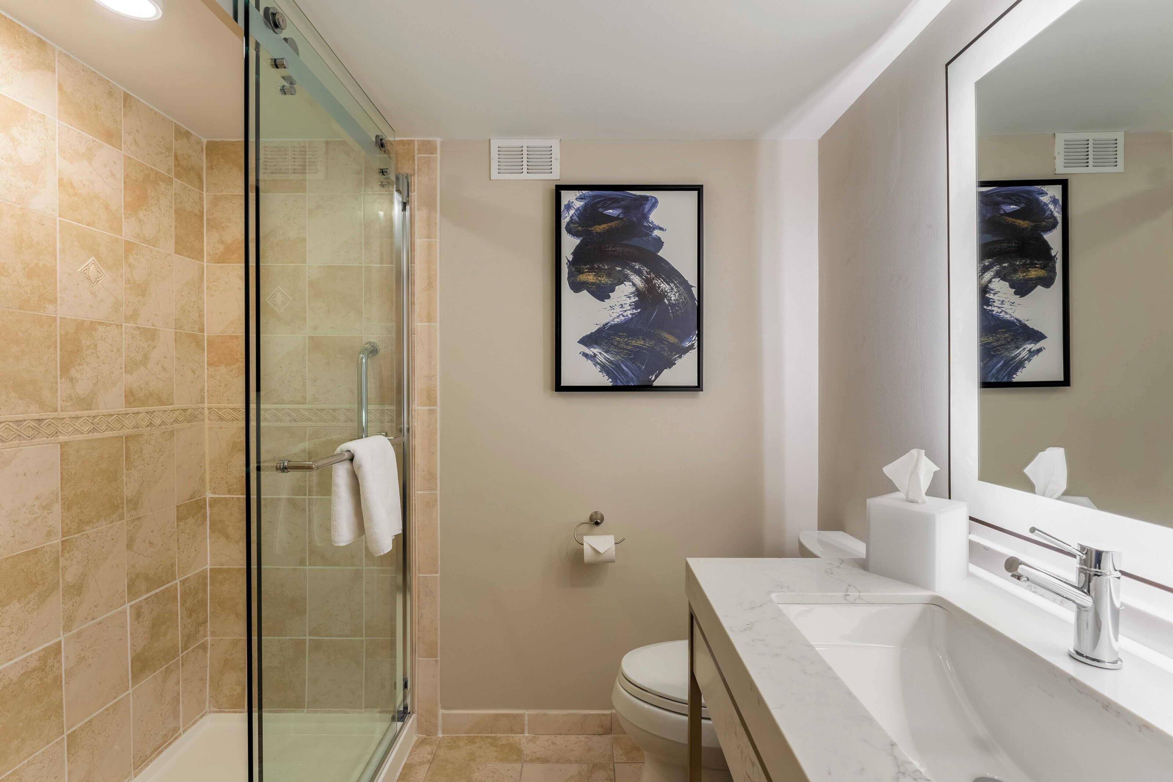 Une salle de bain moderne avec une douche à parois de verre, un lavabo en marbre et un grand miroir.