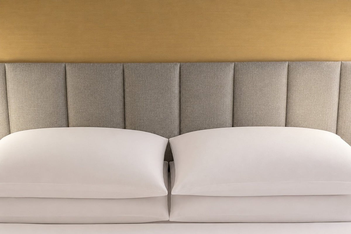 Un lit avec une tête de lit et des oreillers.