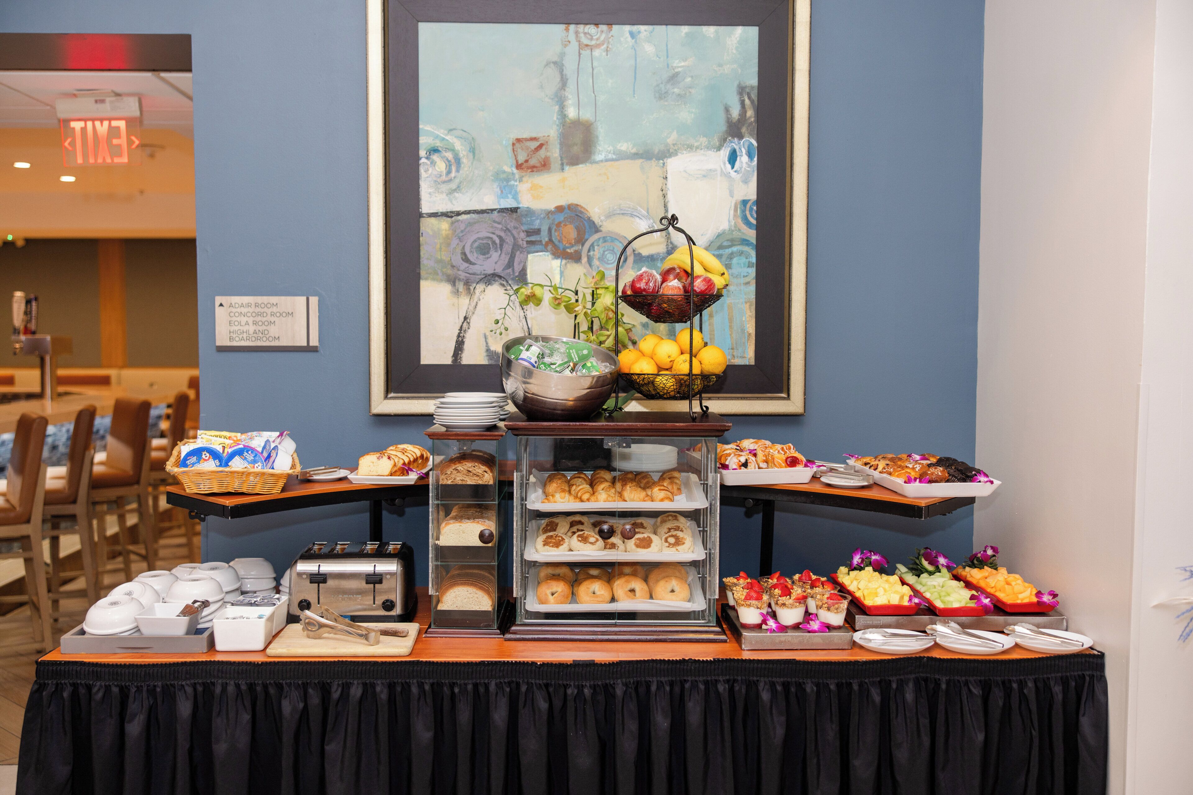 Un buffet garni de divers plats et une peinture accrochée au mur.