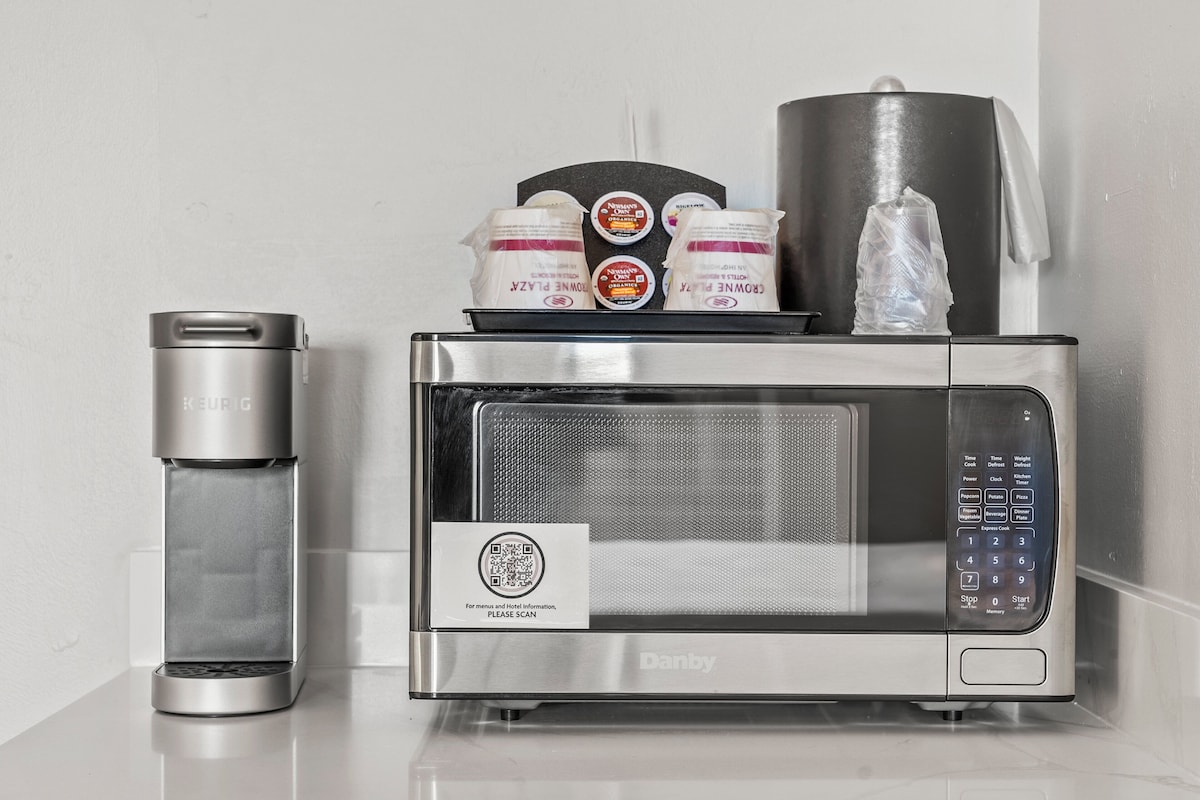Una cocina moderna con cafetera, microondas y dispensador de agua.