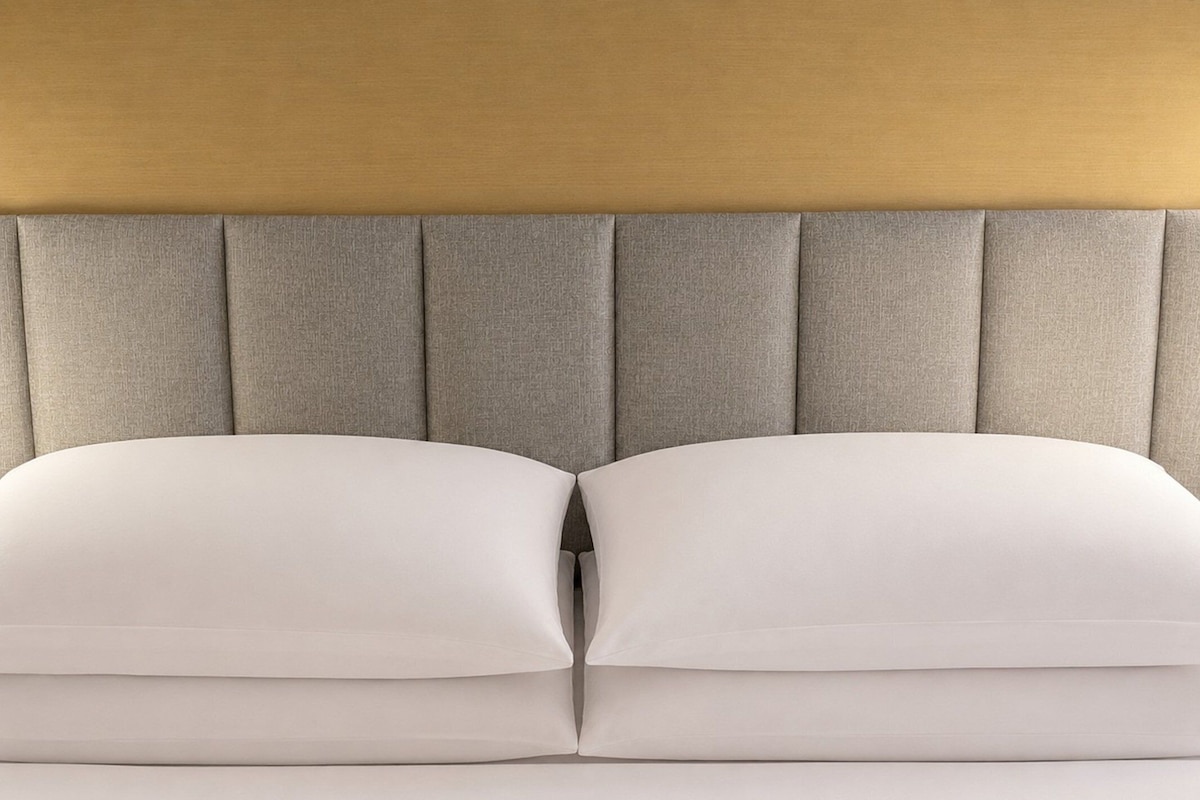 Una cama con cabecera y almohadas.