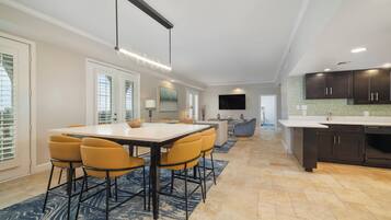 A modern kitchen with dark cabinets, a white countertop, and a built-in oven.