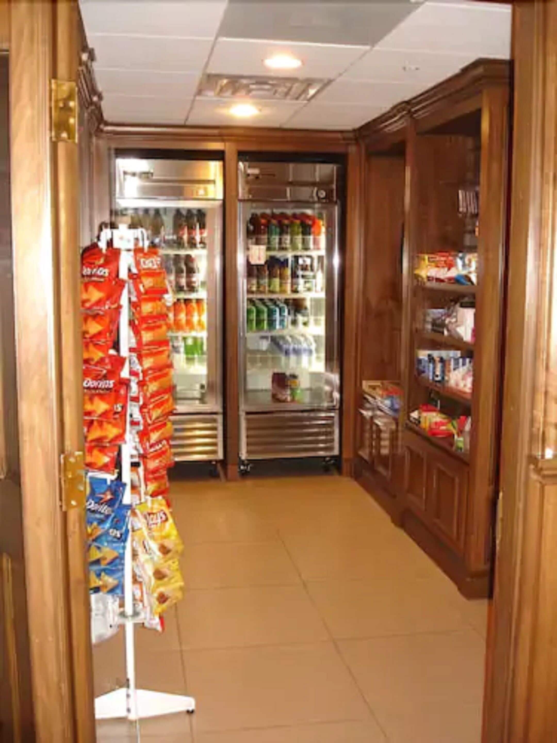 A narrow hallway with a snack vending machine on the left and a refrigerated display case in the center.