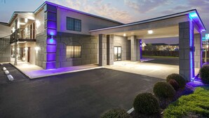 Un hôtel moderne doté d’un hall d’entrée spacieux, d’un parking couvert et d’une façade bien éclairée.