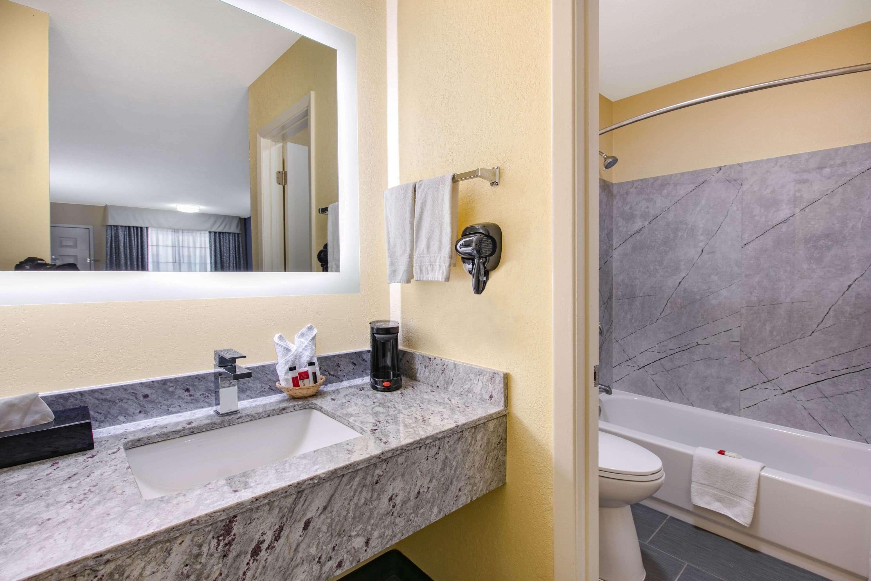 A bathroom with a marble sink, a toilet, and a bathtub.