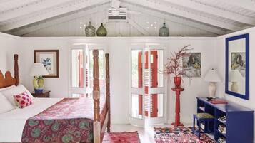 Une chambre à coucher avec un lit en bois, une porte à rayures rouges et blanches, une bibliothèque bleue et un vase rouge.