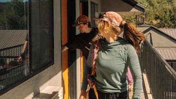 Un balcon donnant sur l’extérieur, une fenêtre et une porte menant à un espace intérieur.