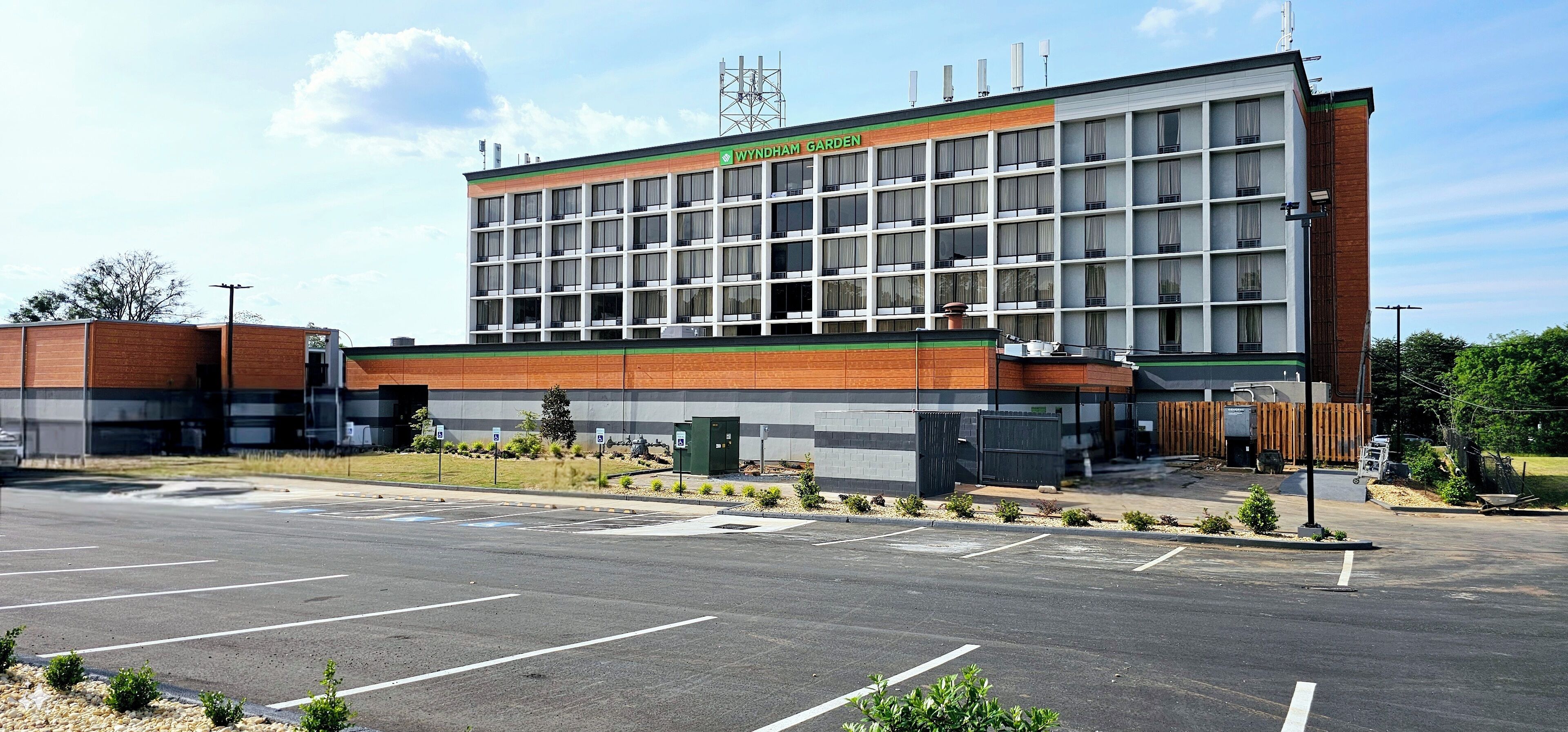 A multi-story building with a sign reading "Wyndham Garden." It features a modern architectural design with a mix of brick and glass facade.