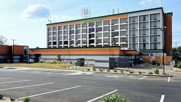 A multi-story building with a sign reading "Wyndham Garden." It features a modern architectural design with a mix of brick and glass facade.