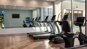 A gym with treadmills, exercise bikes, and a large mirror. - Wyndham Garden Atlanta Airport (College Park)