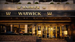 A hotel entrance with a glass facade, a name sign above the doors, and a canopy over the entrance. - Warwick Paris Champs-Elysées (Paris)