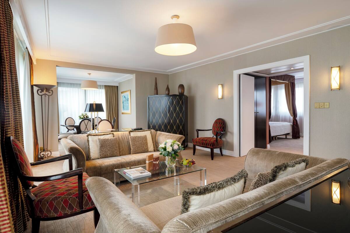 A modern living room with a sofa, armchairs, a coffee table, and a cabinet.