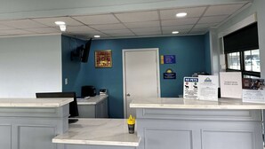 A reception area with a marble counter, a closed door, and informational signs including a 'No Pets' policy. - Days Inn by Wyndham Lake Charles (Lake Charles)
