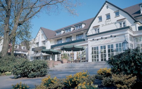 A hotel with a traditional European architectural style, featuring a large entrance with a covered patio area.