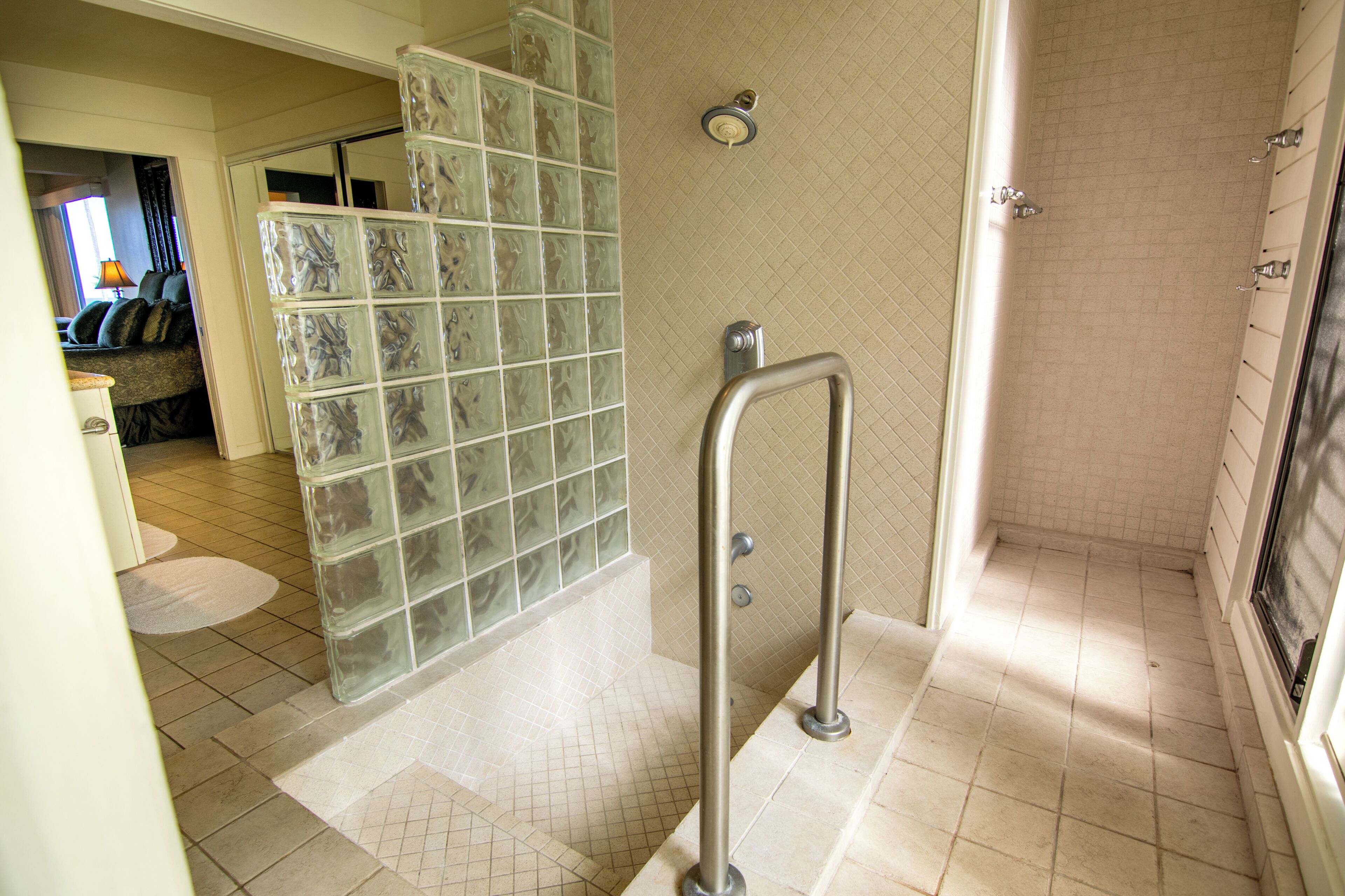 A bathroom with a glass shower enclosure, a walk-in shower, and a tiled floor.