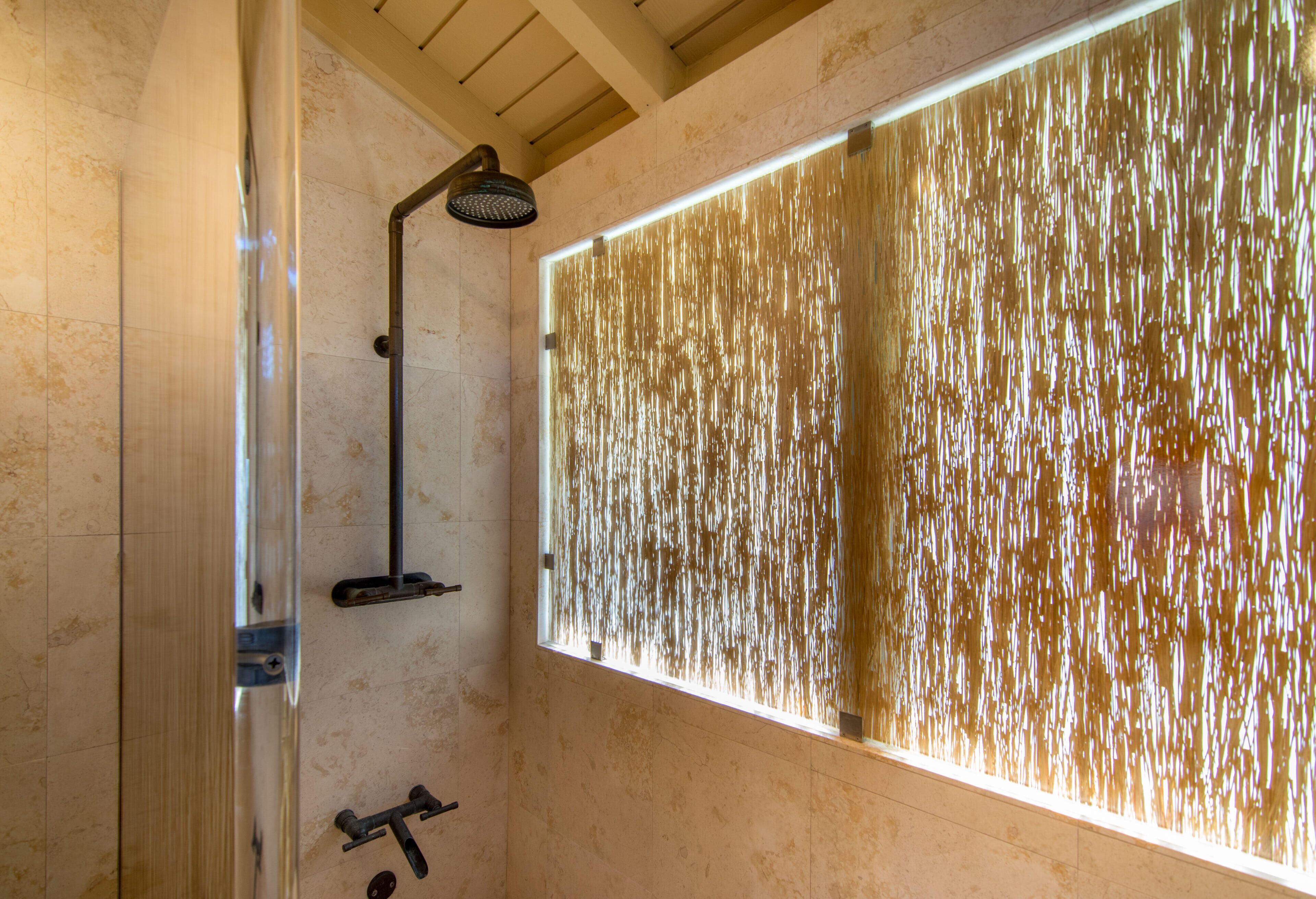 Une salle de bain moderne dotée d’une grande fenêtre, d’une douche et d’un porte-serviettes.