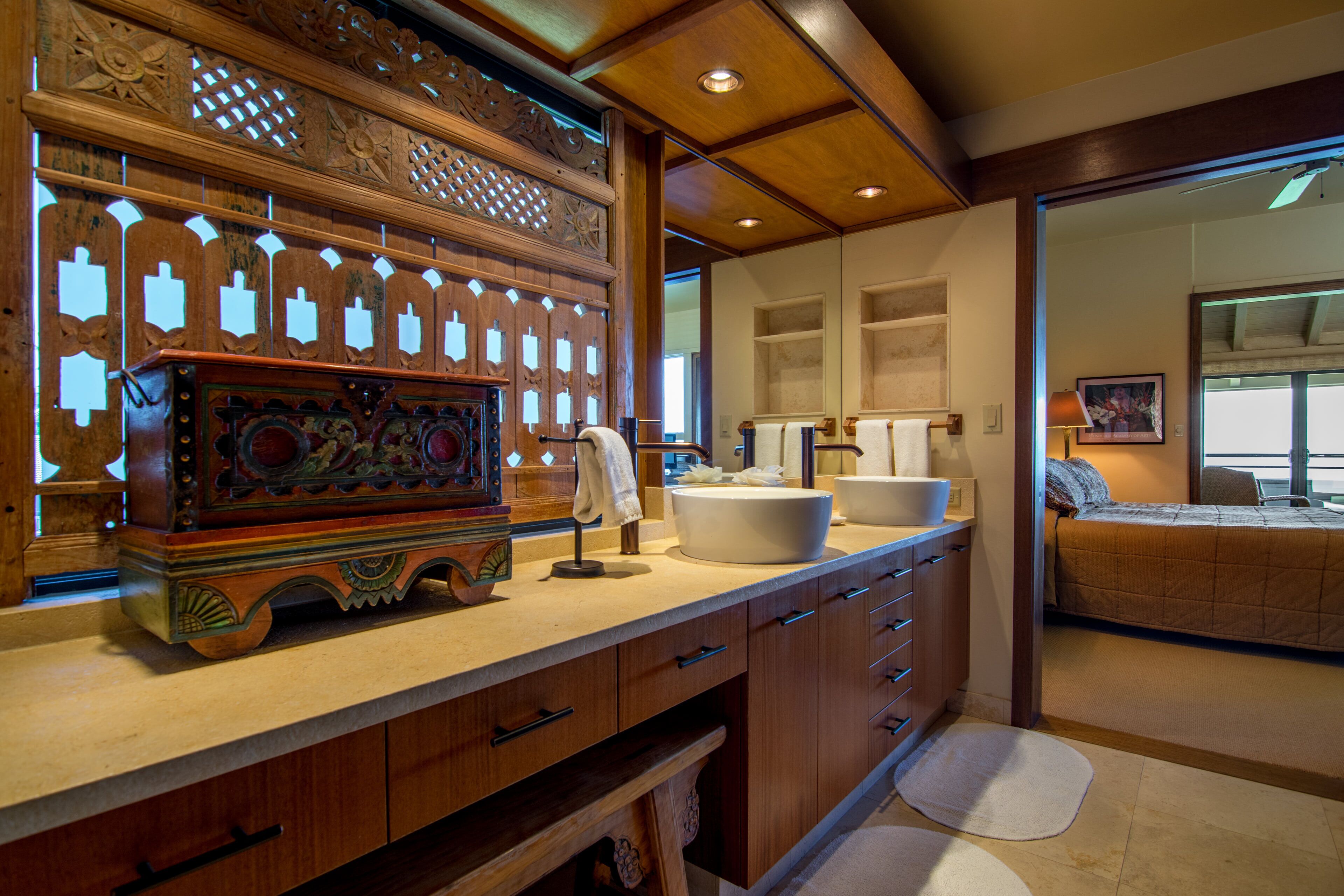 A wooden vanity with a sink, a mirror, and a decorative piece.