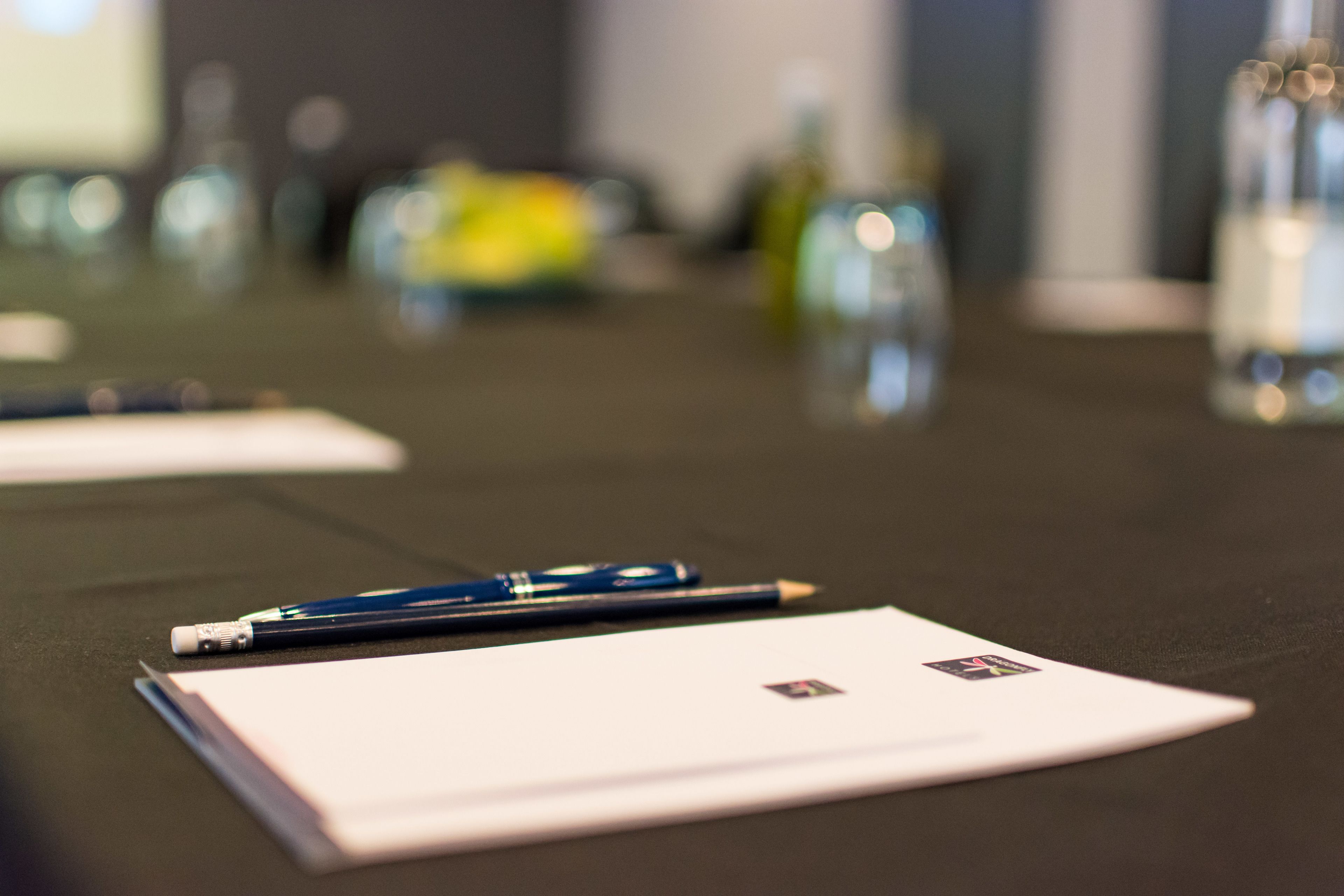 A conference table with a notepad, a pen, and a bottle of water.