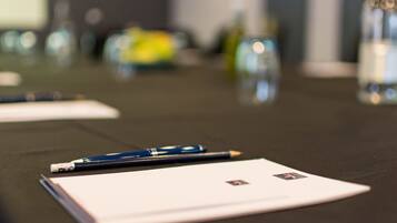 A conference table with a notepad, a pen, and a bottle of water.