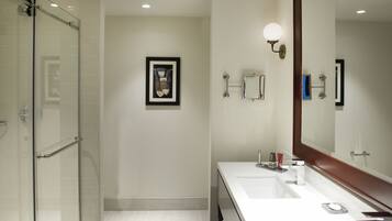 A modern bathroom with a glass shower enclosure, a double sink vanity, and a large mirror.
