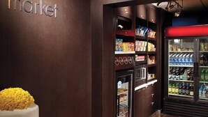 A grocery store interior with shelves stocked with snacks and beverages, a refrigerated section, and a sign reading "the market". - Courtyard by Marriott - Atlanta Executive Park/Emory (Atlanta)