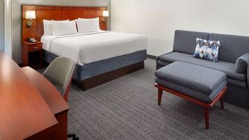 Een hotelkamer met een groot bed, een bank, een kleine tafel en een stoel.
