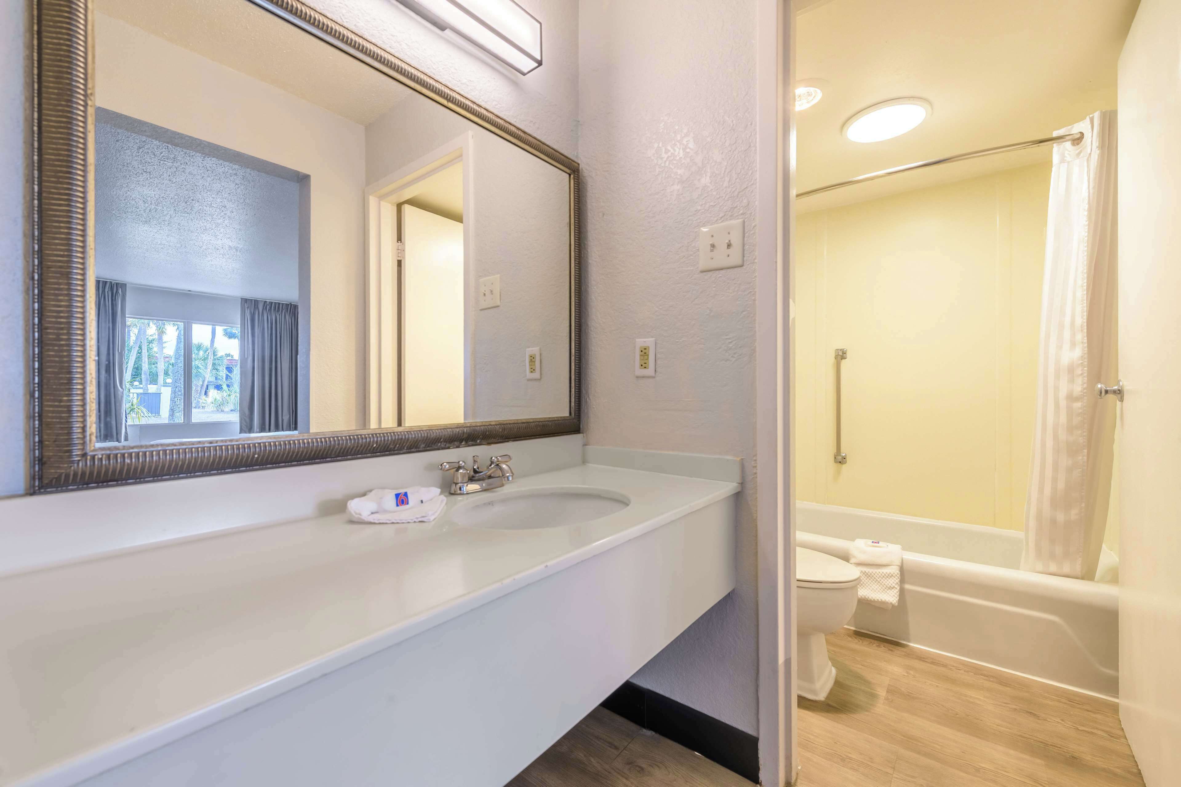 A bathroom with a double sink, a large mirror, a shower, and a toilet.