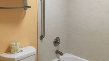 A bathroom with a toilet, a bathtub, and a shower.