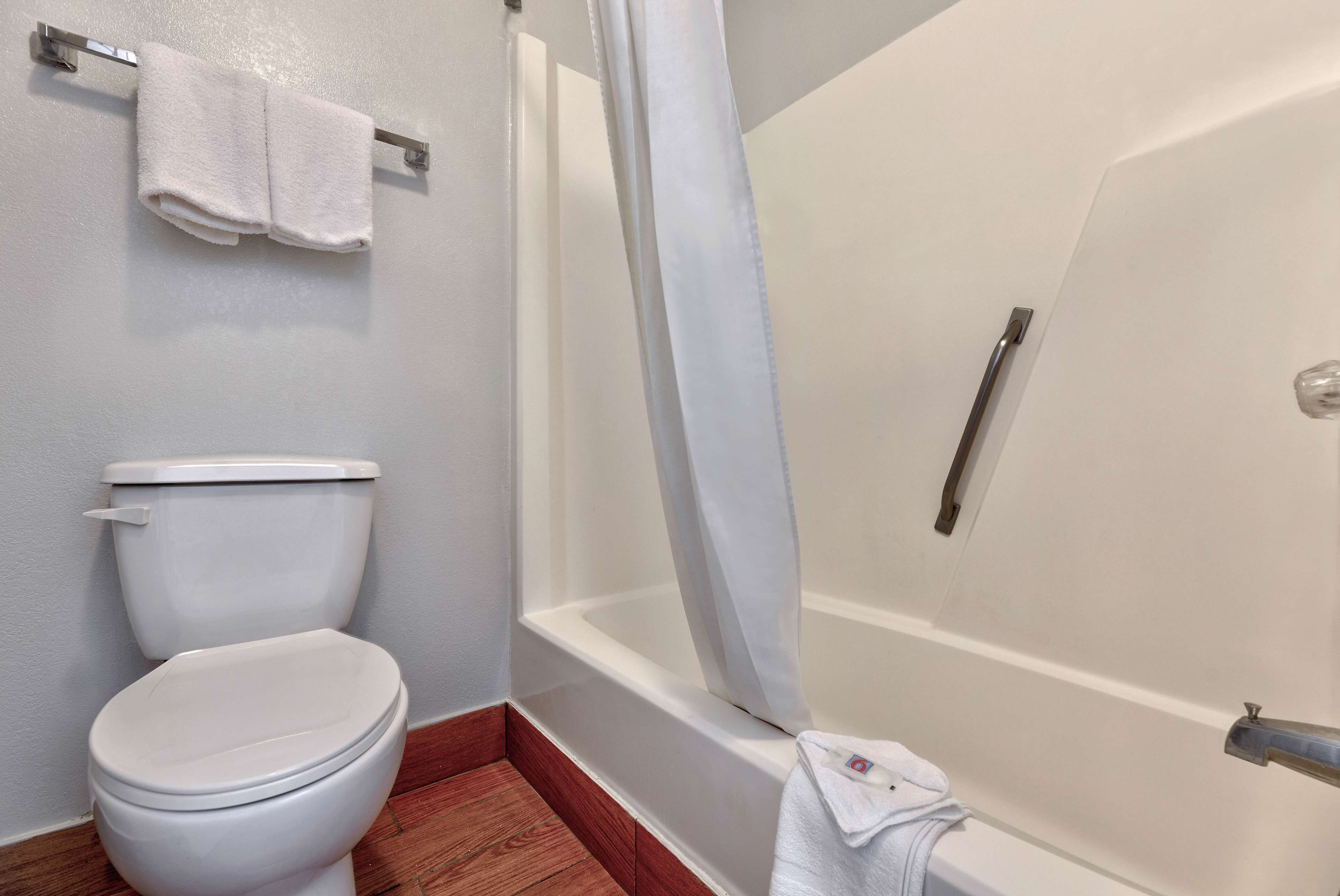 A bathroom with a toilet, a bathtub, and a shower curtain.