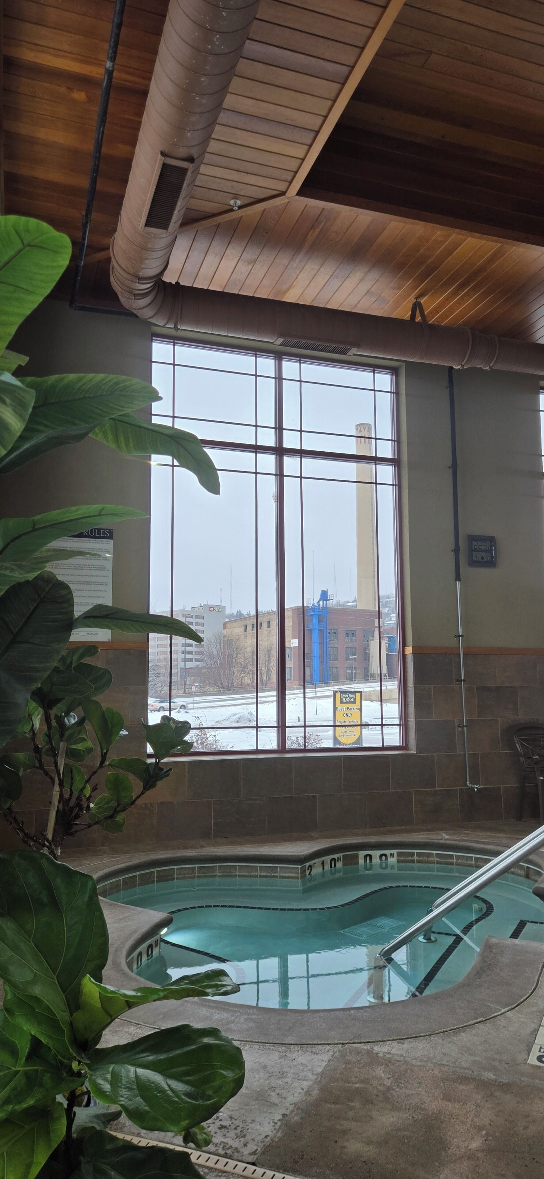 An indoor swimming pool with a view of a building outside.