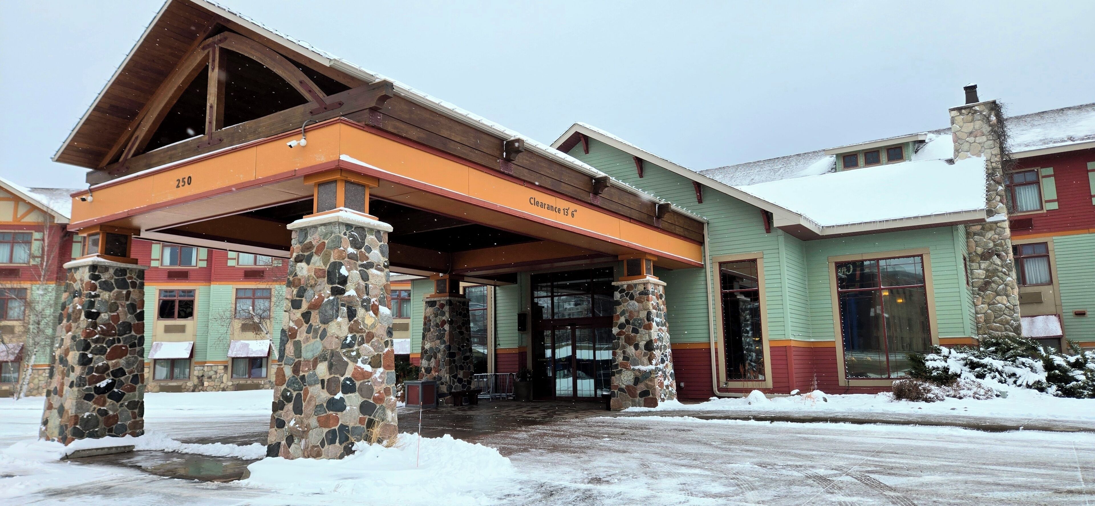 A building with a stone pillar entrance, a covered porch, and a sign reading 'Clearance 250'.