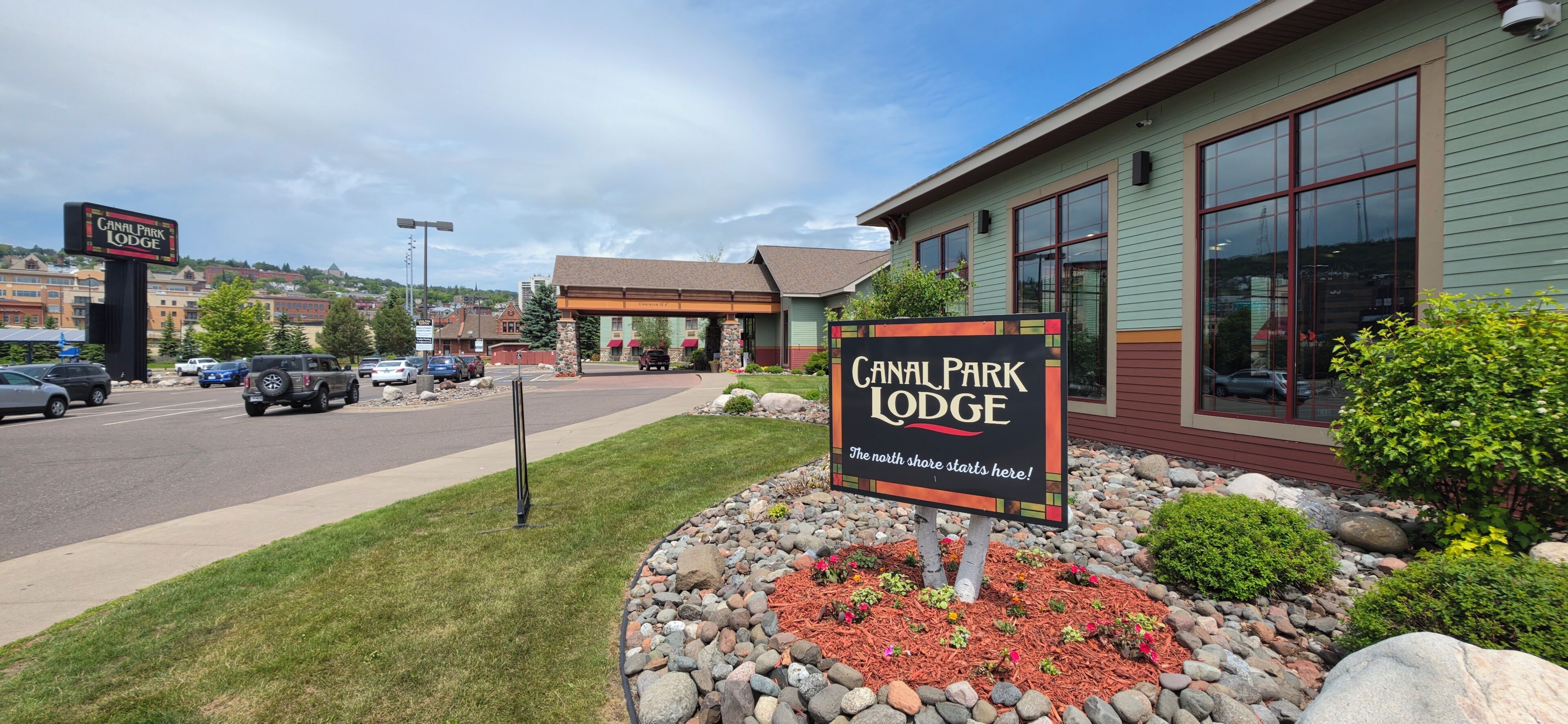 Canal Park Lodge bygning med skilt, parkeringsplads og grøn beplantning omkring.