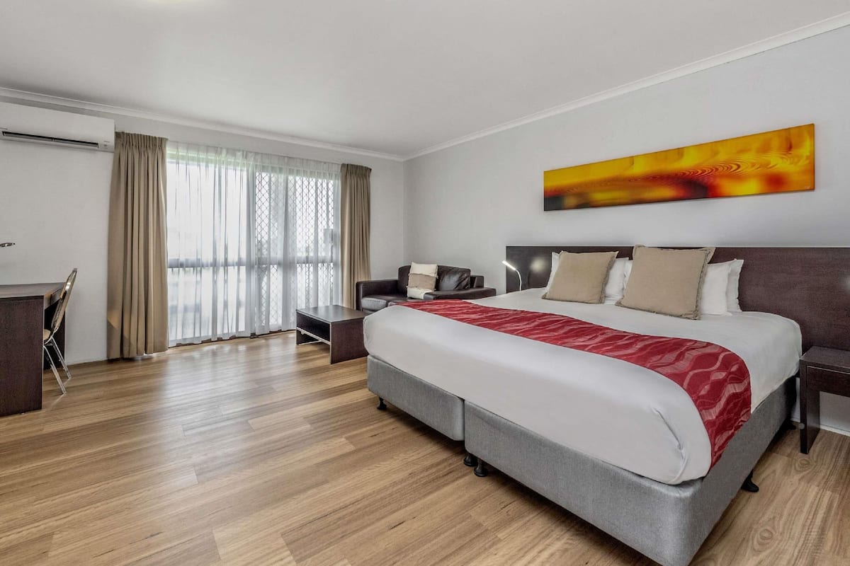 Une chambre d’hôtel moderne avec un grand lit, un bureau et une chaise.
